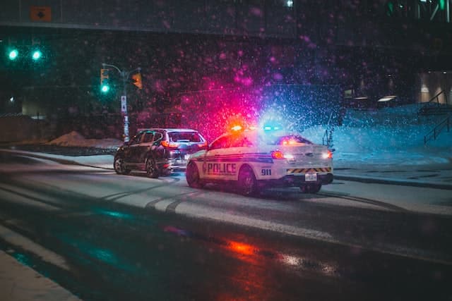 coche de policía tirando de alguien en la nieve
